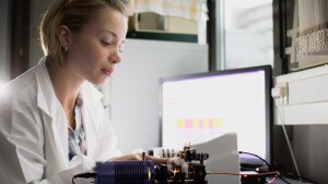 Eine Forscherin baut eine elektronische Apparatur in einem Labor auf